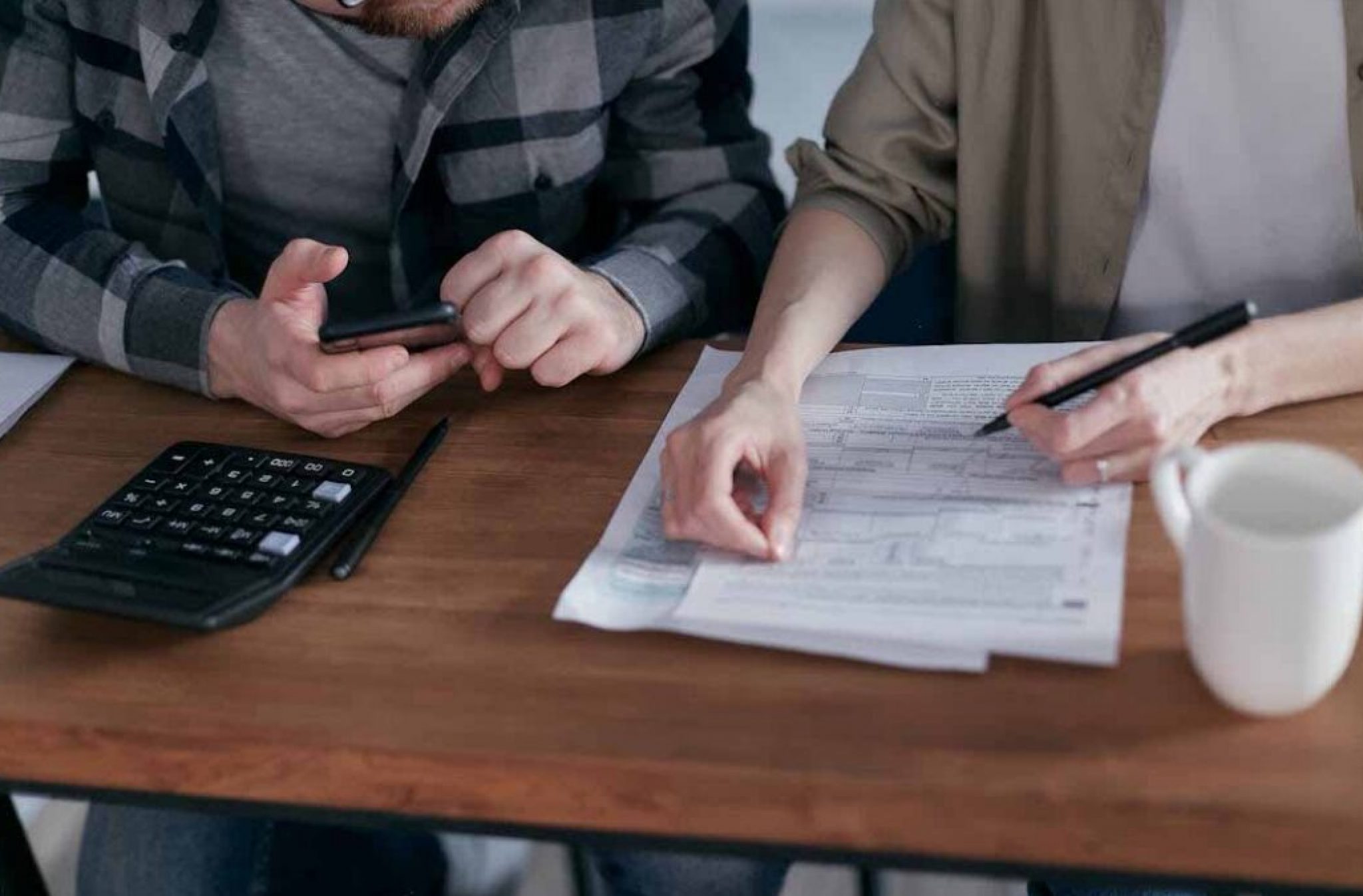 Business-owners-reviewing-tax-return-documents-with-a-calculator-representing-organised-tax-preparation-and-financial-compliance-new-blog-image-1-1080x675